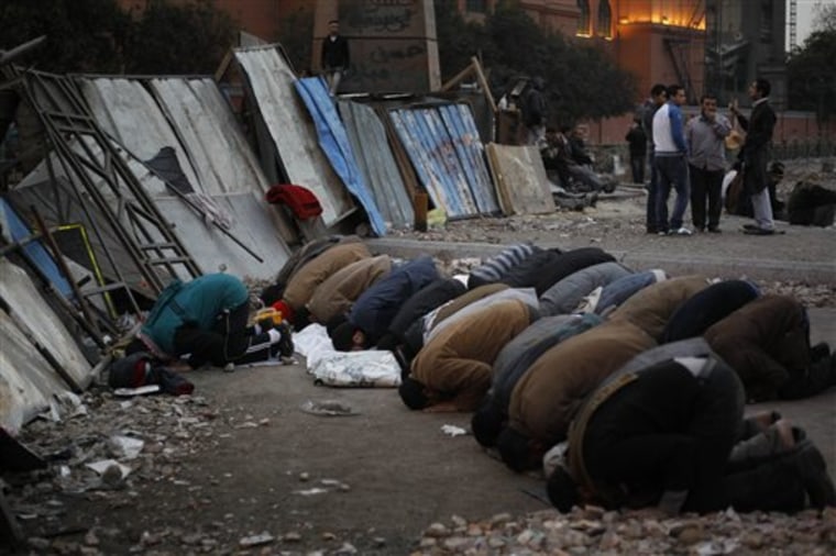 Egyptian anti-government demonstrators pray at a barricade protecting the group from possible attacks by pro-government protesters in Tahrir Square, the center of anti-government demonstrations, in Cairo, Egypt on Sunday.